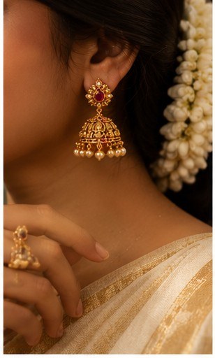 Close up of jhumka earring styled with jasmine hair flowers