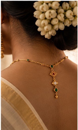 Back view of a gold necklace clasp on a saree
